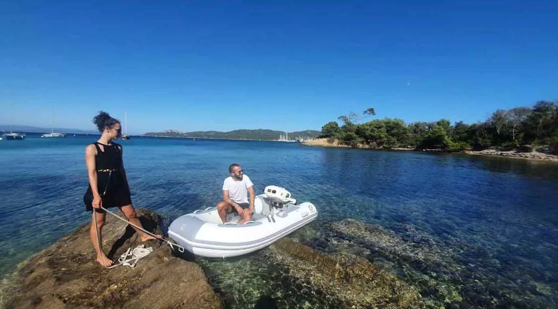 Person operating inflatable boat motor